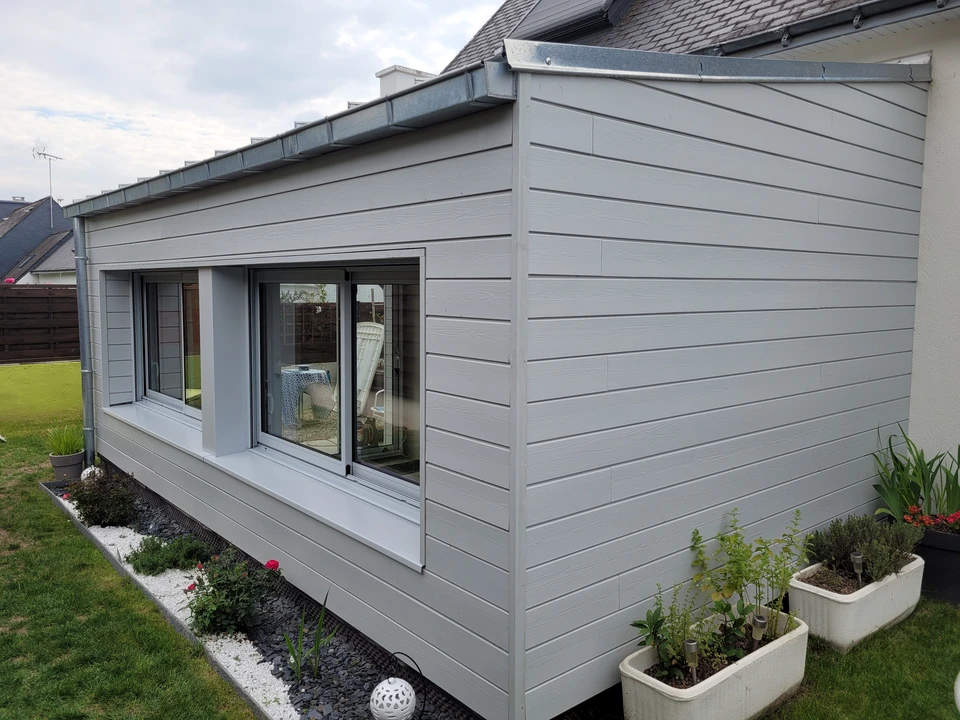 Extension contemporaine en bardage bois vertical à claire-voie, essence résineux clair non traité